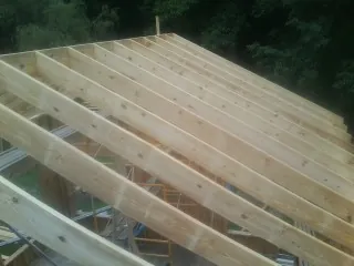 New roof rafters set over an addition before sheathing in Tennessee Colony