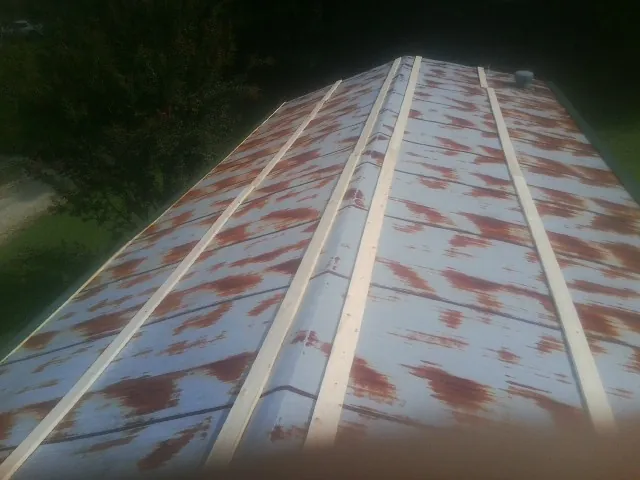 Rusted metal roof panels with new wood purlins before replacement — Storm Damage Roof Repair in Tennessee Colony by Roofing Brothers